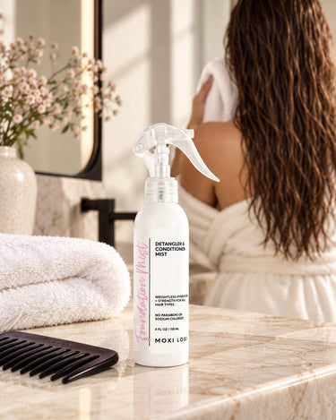 Moxi Loxi Foundation Mist 4 fl oz beside an ivory towel and wide-tooth comb after washing and conditioning