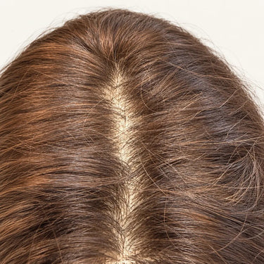 Close-up of the Sienna silk base topper part showing realistic scalp appearance and dimensional brown strands.